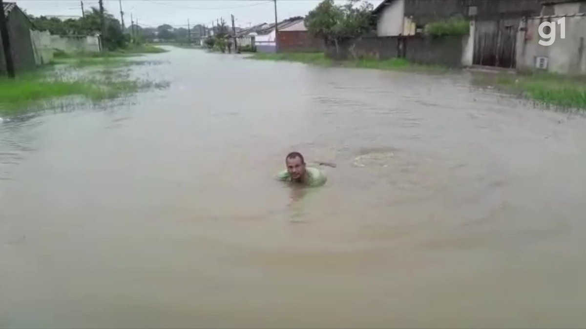 Morador nada em rua alagada em Araruama, RJ; problemas foram registrados em diversos bairros após chuva