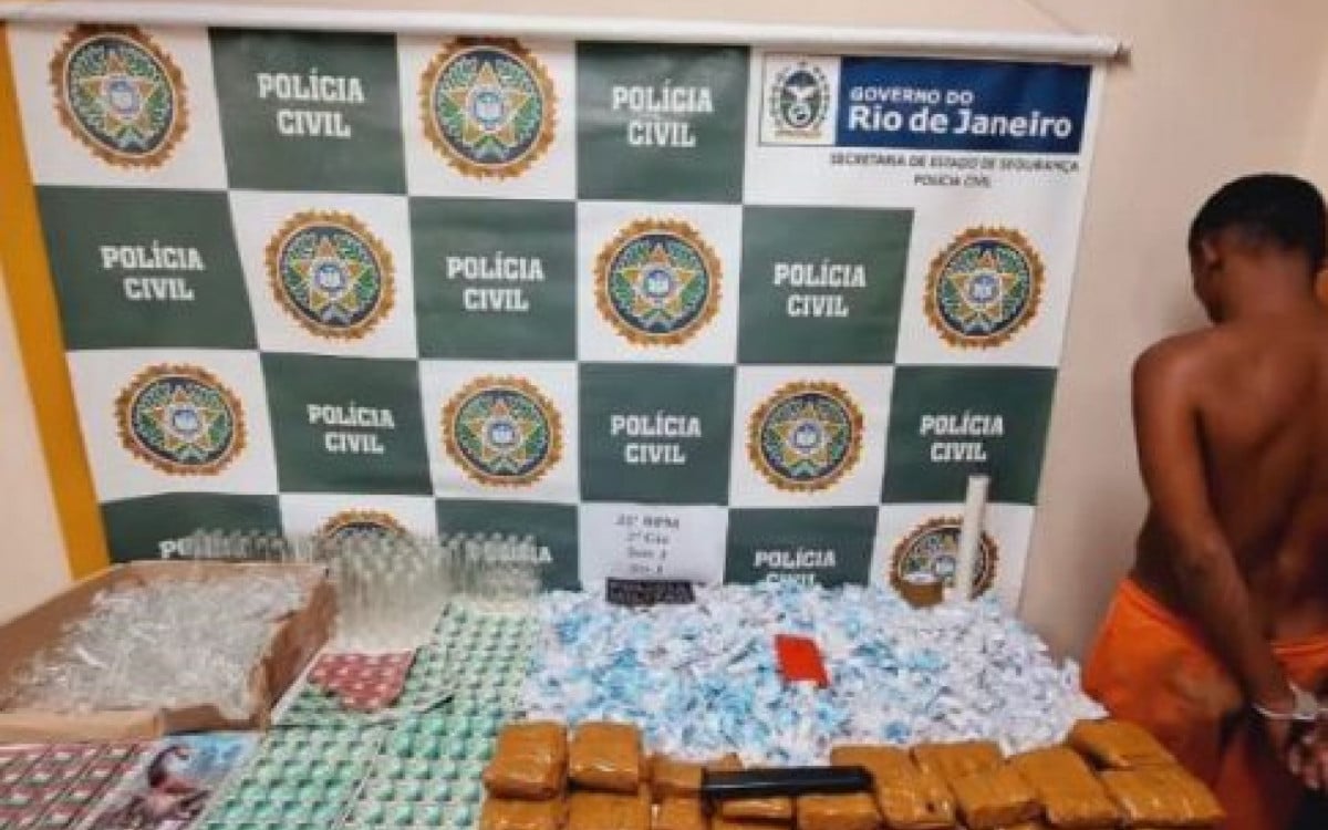 L. F. A. M, de 19 anos. Com 620 pinos de cocaína, um carregador alongado de pistola 9mm com três munições, um aparelho celular e farto material de endolação