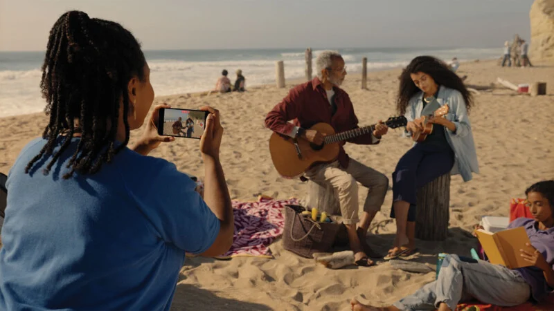 Mulher filmando em uma praia com iPhone