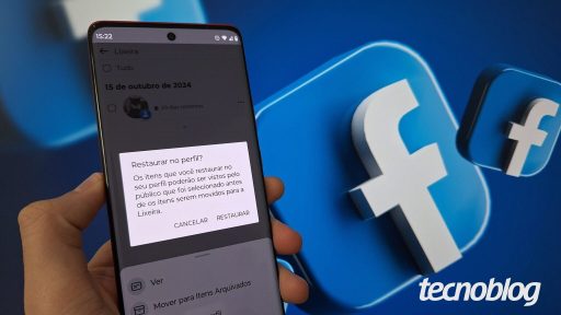 Uma mão segura um celular com o Facebook aberto na opção para restaurar imagem