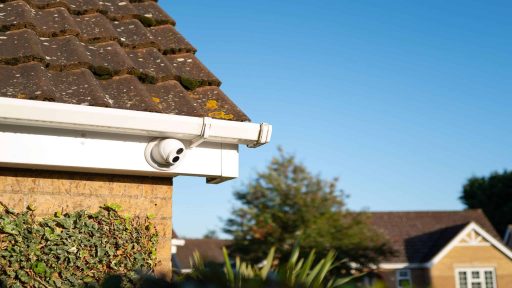 Câmera de CCTV de cor dia e noite do tipo cúpula recém-instalada, fixada nas beiradas de um bungalow privado. Uma de várias câmeras para monitorar um beco sem saída.