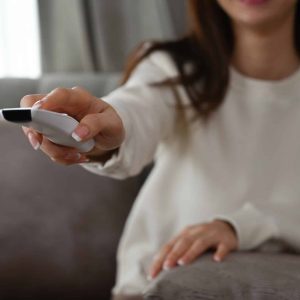 Pessoa com controle de smart tv na mão