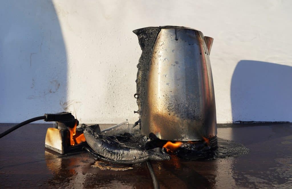 Chaleira elétrica em chamas. A chaleira pegou fogo devido a um curto-circuito.