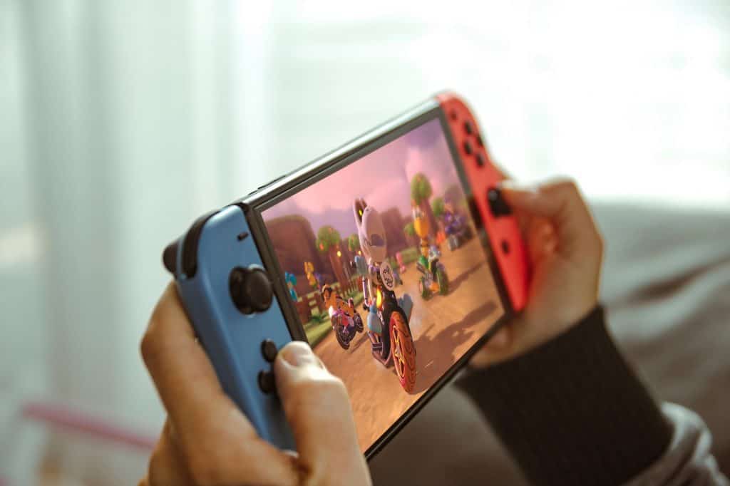 5 maneiras de aprimorar sua vivência no Nintendo Switch Online Guia Região dos Lagos 10 Jovem jogando com um console portátil Nintendo Switch