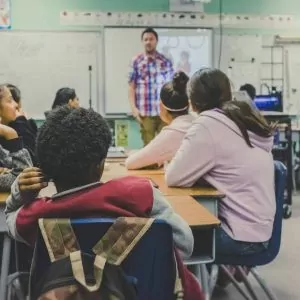 Professor em sala de aula via Kenny Eliason/Unsplash