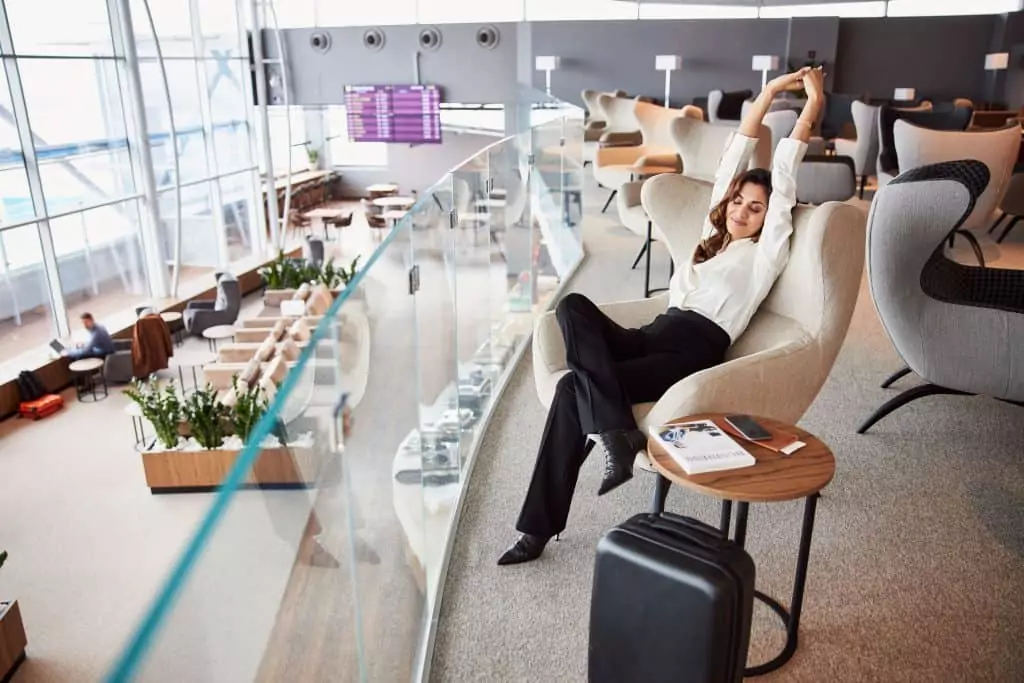 Como elaborar um plano de viagem com IA no Speakspots.com Guia Região dos Lagos 8 Imagem de mulher relaxando na sala de espera do aeroporto, esperando pelo voo