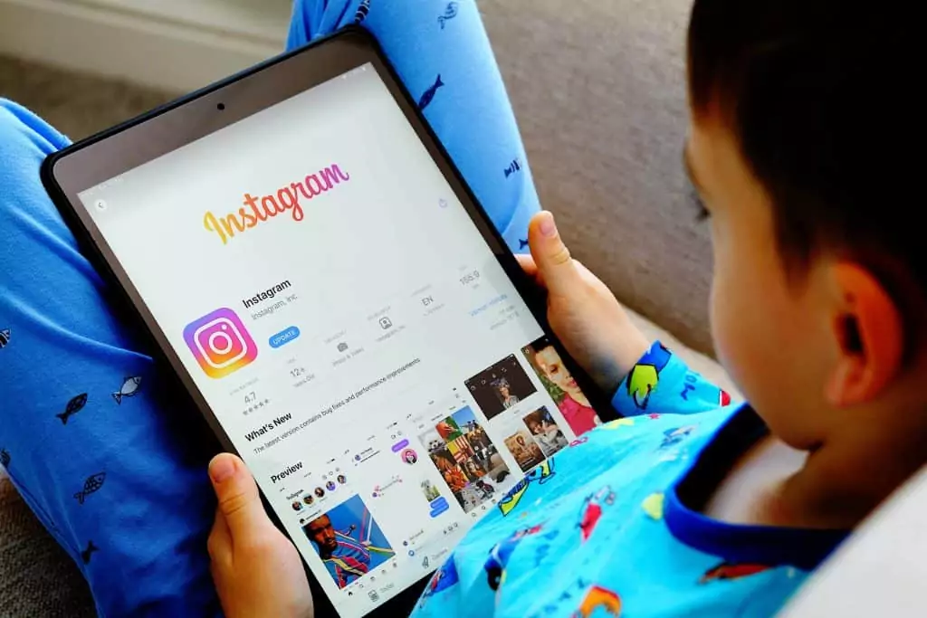Criança usando aplicativo do Instagram em um tablet