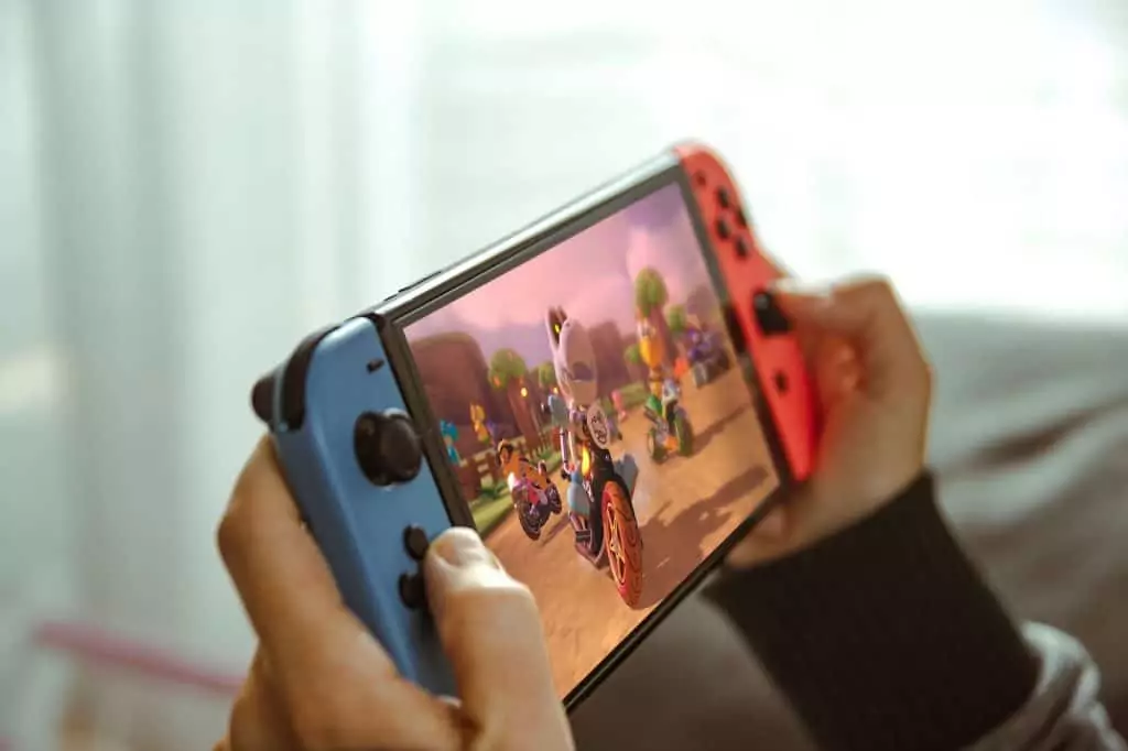 Jovem jogando com um console portátil Nintendo Switch